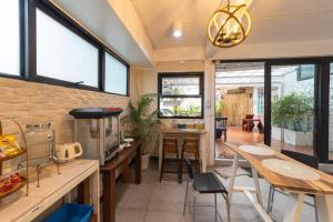 a kitchen with tables and chairs and windows at The Rock Samui - formerly known as The Rock Residence - SHA Extra Plus in Lamai