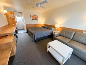a hotel room with a bed and a couch at Summerhill Motor Inn in Merimbula +40 photos