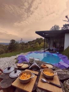 una mesa con tazones de comida junto a una piscina en Septimo Cielo Tiny Homes, en Guatapé