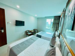 pokój hotelowy z 2 łóżkami i telewizorem w obiekcie KEN HOTEL w Ho Chi Minh