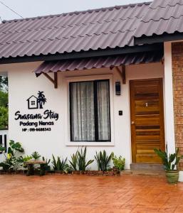 瓜拉丁加奴的住宿－Suasana Stay & Homestay near UMT UNISZA IPG MRSM Kuala Nerus, Terengganu，房屋的一侧有标志