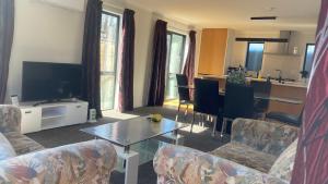 un soggiorno con divani e tavolo e una cucina di Newly built house a Lower Hutt