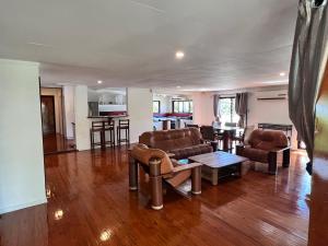 a living room with two couches and a kitchen at Tropical Garden-04-G in Nadi