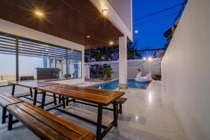 a patio with two wooden benches and a swimming pool at Blue Sea Villa Vũng Tàu 5 in Vung Tau