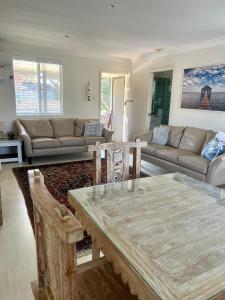 a living room with a table and a couch at Coconuts - 2 balconies and stroll to choice of 2 beaches in Nelson Bay
