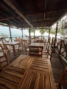a restaurant with wooden tables and wooden chairs at Thani Ecobeach Barú in Playa Blanca