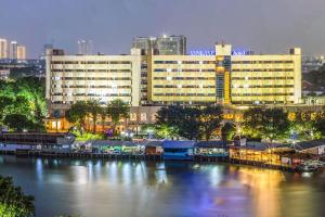 ジャカルタにあるSunlake Waterfront Resort & Conventionの都市の川の横にある大きな建物
