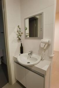 ein weißes Badezimmer mit einem Waschbecken und einem Spiegel in der Unterkunft G Residence - 2R2B Barrington Night Market (1) in Brinchang