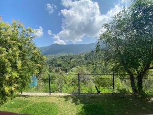 a fence with a view of a mountain at The Nature House Village Homestay in Mukteswar