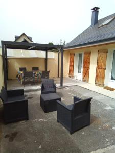 un patio con sillas y una mesa en un edificio en Gîtes de la vallée des gaves, en Préchac