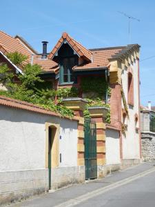 Una casa con una puerta verde a un lado. en Forge Saint Martin, en Mary-sur-Marne