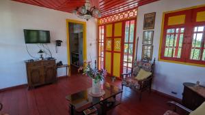 ein Wohnzimmer mit einer Vase mit Blumen auf einem Tisch in der Unterkunft Coronel's Peak Coffee House in Salento