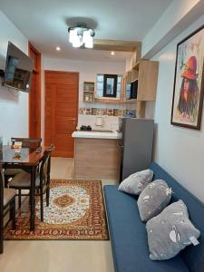 ein Wohnzimmer mit einem blauen Sofa und einer Küche in der Unterkunft Apartamento familiar elegante 2 in Cusco