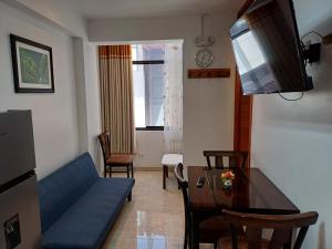 ein Wohnzimmer mit einem blauen Sofa und einem Tisch in der Unterkunft Apartamento familiar elegante 2 in Cusco
