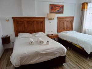 ein Schlafzimmer mit 2 Betten und Handtüchern darauf in der Unterkunft Apartamento familiar elegante 2 in Cusco