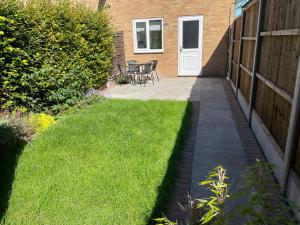 a garden with a lawn and a patio at Cozy 2 bedroom house with parking, Aylesbury in Buckinghamshire