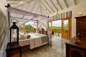 a bedroom with a canopy bed and a balcony at The Divine Villa in Talpe +74 photos