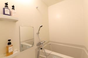 a bathroom with a bath tub and a mirror at The Grand Residence Hotel Hakata in Fukuoka