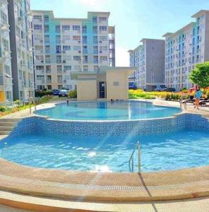 a large swimming pool in a city with tall buildings at Seawind 2 bedroom comfort in Davao City