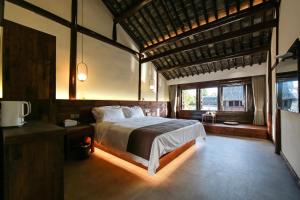 Un dormitorio con una cama y una ventana grande en Tingjian Guli Private Bath Design Homestay - Nanxun Ancient Town Baijianlou Scenic Area, en Huzhou