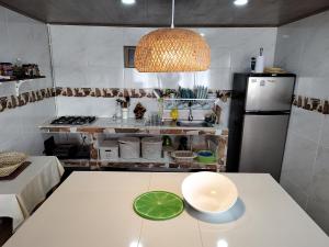 a kitchen with a white table with a green bowl on it at Hospedaje Las Golondrinas in Tibirita