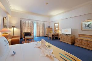 una camera d'albergo con letto e scrivania di Sunlake Waterfront Resort & Convention a Giacarta