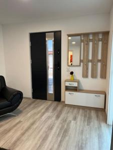 a living room with a black door and a black chair at EG-Souterrain Wohnung in Marburg an der Lahn