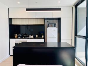 eine Küche mit schwarzer Arbeitsplatte und Kühlschrank in der Unterkunft Urban Chic Retreat near Crown w/ Free Parking in Melbourne + 12 Fotos
