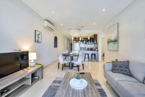 a living room with a couch and a table at Central City Apartment, Pool & Gym, 2 car parks in Darwin
