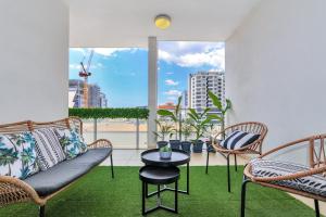- un salon avec un canapé, des chaises et une table dans l'établissement Central City Apartment, Pool & Gym, 2 car parks, à Darwin