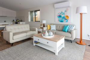 a living room with two couches and a coffee table at Eco Elegance in Cape Paterson in Cape Paterson