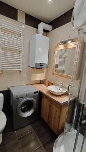 a bathroom with a washing machine and a sink at Tabago Studio 11 in Nysa