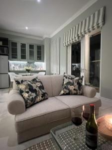 Cape Town的住宿－Two on Milner - OAK TREE COTTAGE - Stylish open-plan Guesthouse in Rondebosch，客厅配有沙发和桌子