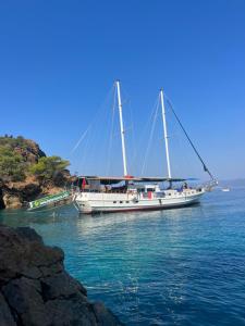 a boat floating in the water next to a cliff at Beforelunch Cruise in Fethiye