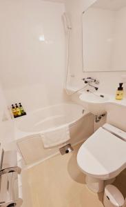 a white bathroom with a toilet and a sink at Hotel Excellence Kyoto Station Nishi in Kyoto