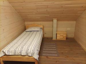 a room with a bed in a wooden cabin at Pirts Jaunakmeni in Priežmale