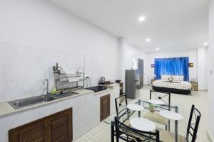 a kitchen with a sink and a table and chairs at Grand View Premium in Patong Beach