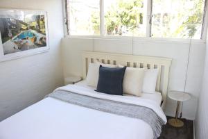 - une chambre avec un lit doté de draps et d'oreillers blancs dans l'établissement Boutique Paddington Apartment with CBD Views, à Sydney