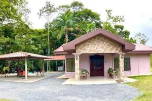Cette petite maison rose dispose d'une terrasse couverte. dans l'établissement Casa Montaña & Spa Pital de San Carlos Costa Rica, à Pital
