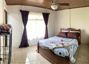 - une chambre avec un lit et un ventilateur de plafond dans l'établissement Casa Montaña & Spa Pital de San Carlos Costa Rica, à Pital