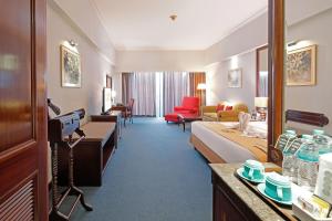 Habitación de hotel con dormitorio y sala de estar. en Sunlake Waterfront Resort & Convention, en Yakarta