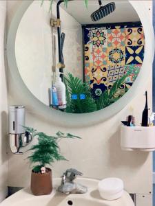 La salle de bains est pourvue d'un miroir et d'un lavabo. dans l'établissement Old House Homestay, à Hanoï