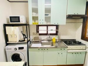 a kitchen with a sink and a washing machine at Aroha house for Foreign guests only in Seoul