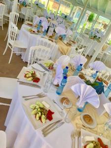 a long table with white tables and white chairs at Hotel Divna in Krumovgrad