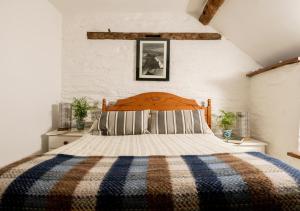 a bedroom with a bed with a checkered blanket at The Granary in Rhayader