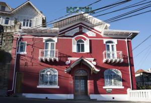 a red house with white trim on a street at Hotel Vista Hermosa 26 in Viña del Mar