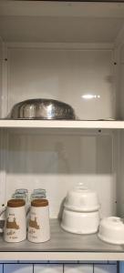 a shelf with bowls and plates in a kitchen at Staycation by A&L in Marilao