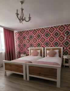 two beds sitting next to each other in a bedroom at Casa Domnească in Giurgiu