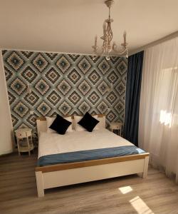 a bedroom with a bed with a wall at Casa Domnească in Giurgiu