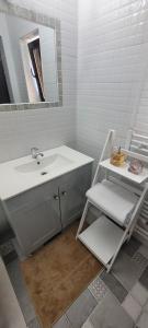 a white bathroom with a sink and a mirror at Casa Domnească in Giurgiu